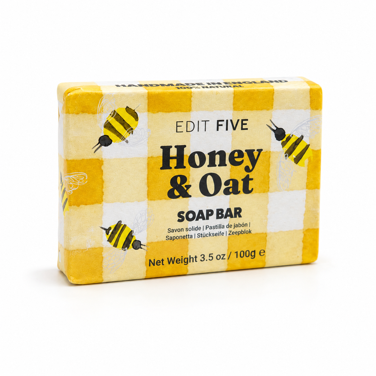 A rectangular bar of Edit Five Honey & Oat soap bar in a yellow and white checkered box with illustrations of bees, photographed on a clean white background. Gift-ready 100g honey and oat body soap with a comforting scent and rich lather, ideal for self-care gift boxes, pamper hampers, stocking fillers and gifts for her or him.