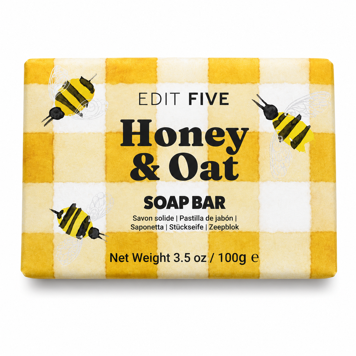 A rectangular bar of soap wrapped in a yellow and white gingham patterned paper sleeve decorated with illustrations of honey bees. The text on the wrapper reads 'EDIT FIVE Honey & Oat SOAP BAR' - Traditional honey and oat soap handmade in England—a mild artisan cleansing bar for everyday skincare, relaxing showers, bath-time rituals and thoughtful wellbeing gifts.