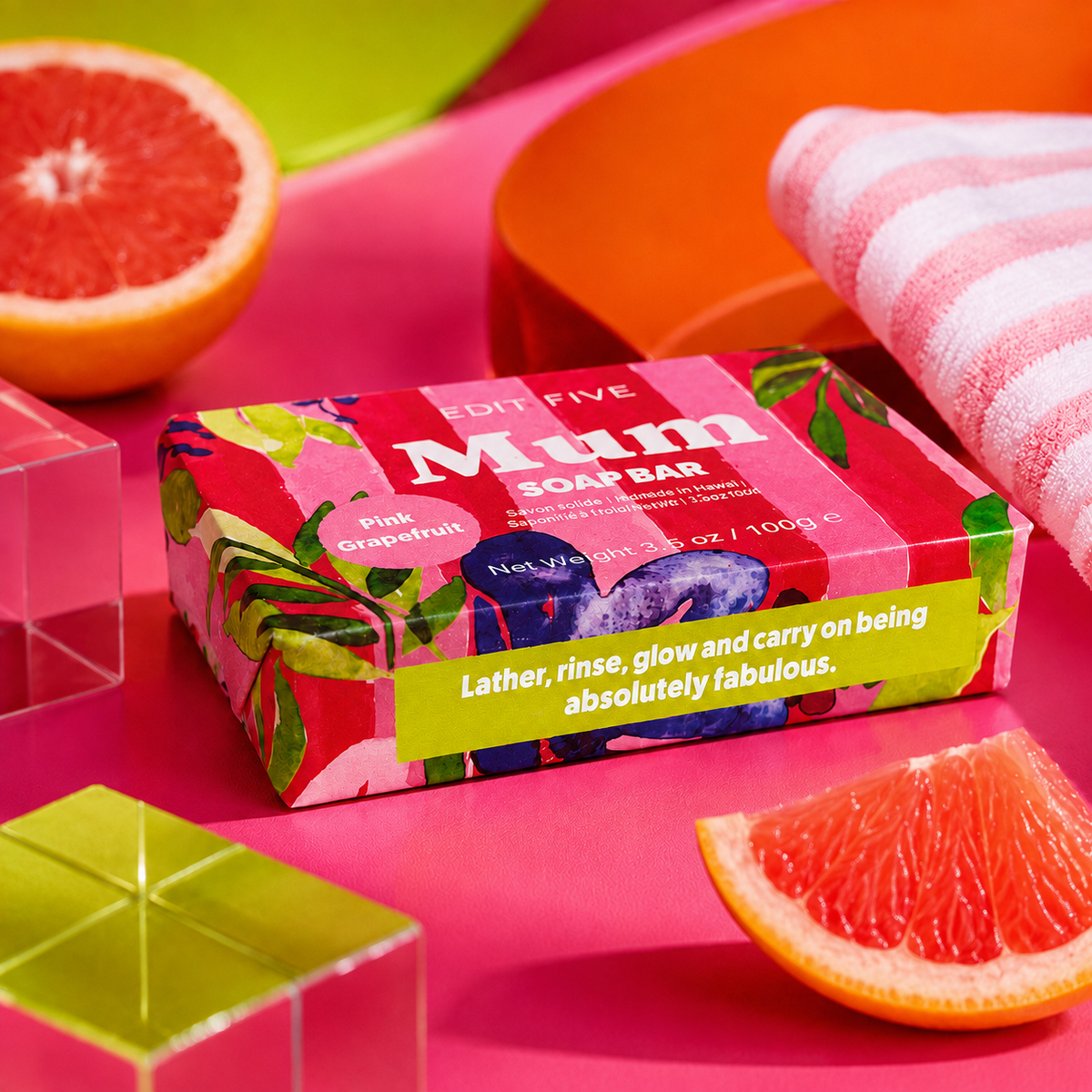 A boxed soap bar package labeled 'EDIT FIVE Mum SOAP BAR' in Pink Grapefruit scent, styled on a bright pink surface with sliced grapefruit, a striped cloth, and acrylic blocks. Edit Five pink grapefruit soap bar designed especially for mums, featuring natural essential oils and beautiful packaging—ideal as a pampering gift, self-care present or gift-box addition.